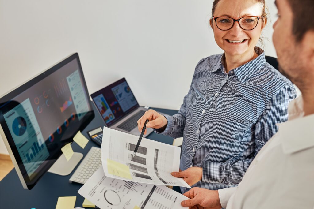 Due professionisti Helea collaborano all'analisi di dati finanziari e business intelligence in ufficio